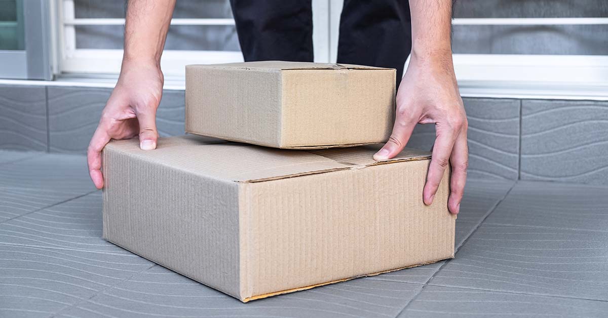someone reaching down and picking up a package at their doorstep