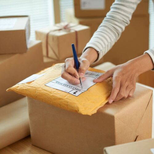 person writing address on package