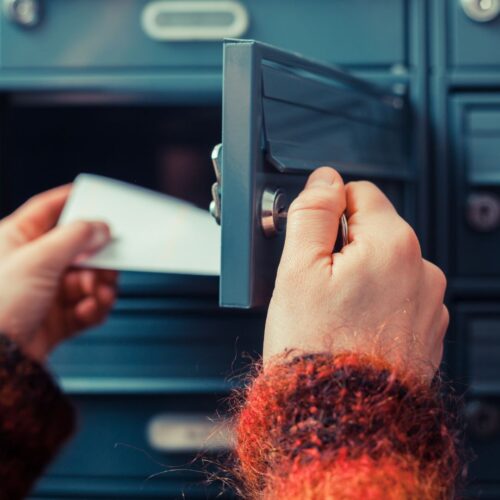 person getting mail out of mailbox