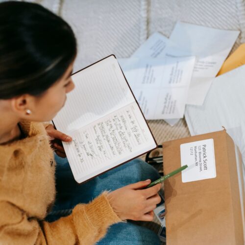 woman writing address on package
