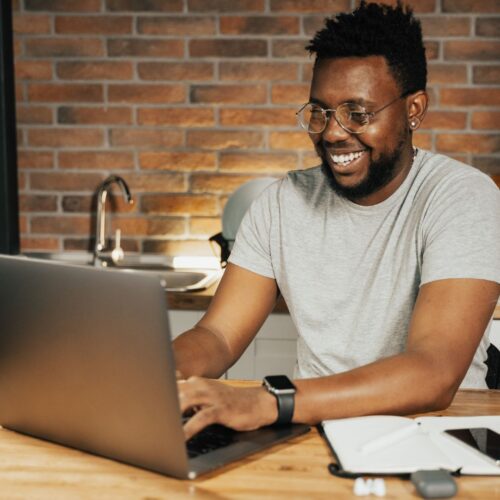 a man smiling while looking at his computer