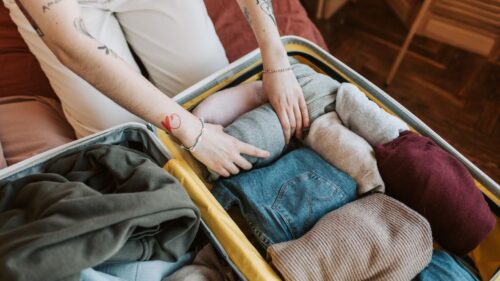 a person packing a suitcase