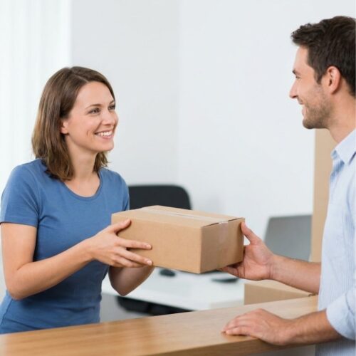 Professional clerk handing a shipped package to a customer at a service counter.
